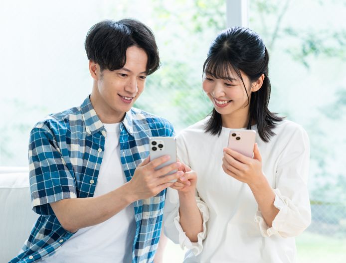 スマートフォンを持った若い男女のイメージ画像